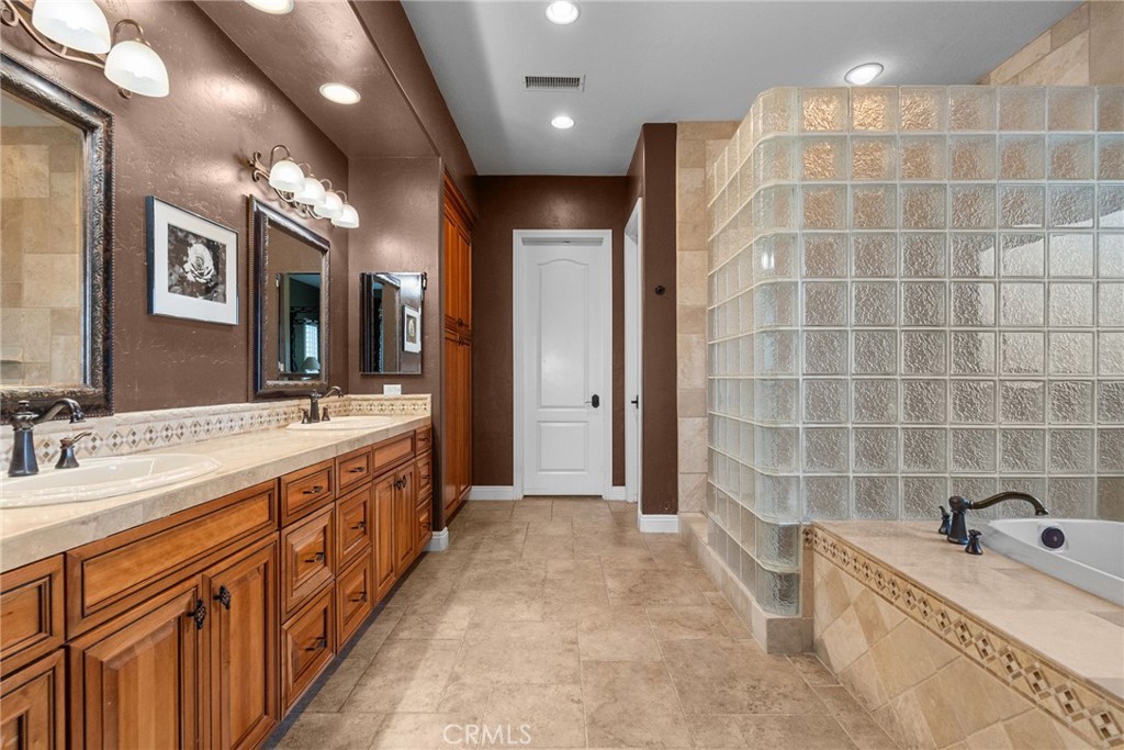35394 Linda Rosea Road Temecula, CA 92592 - Photo 35 of 69 a spacious bathroom with a double vanity sink a large mirror and a bathtub