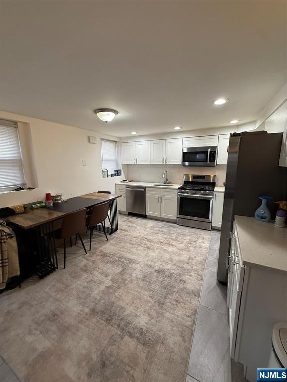 61 Sabina Street, Unit 1 Little Ferry, NJ 07643 - Photo 5 of 16 a kitchen with kitchen island a stove and a refrigerator