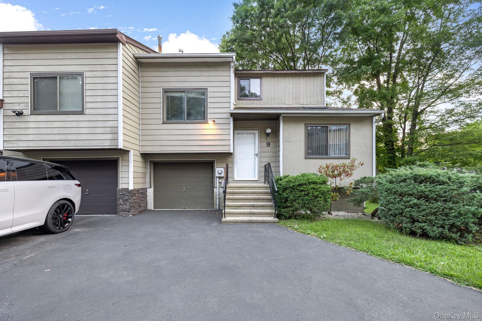 a view of a house with a yard and parking space