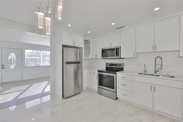 a kitchen with white cabinets stainless steel appliances and a sink