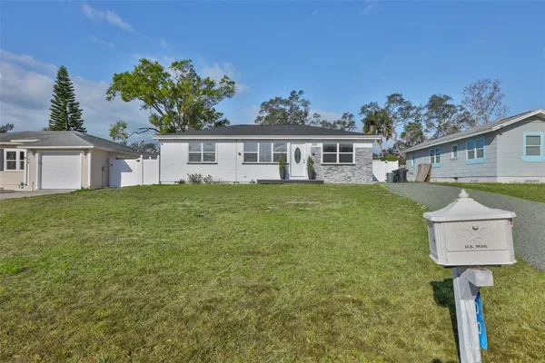 a front view of a house with a yard and trees