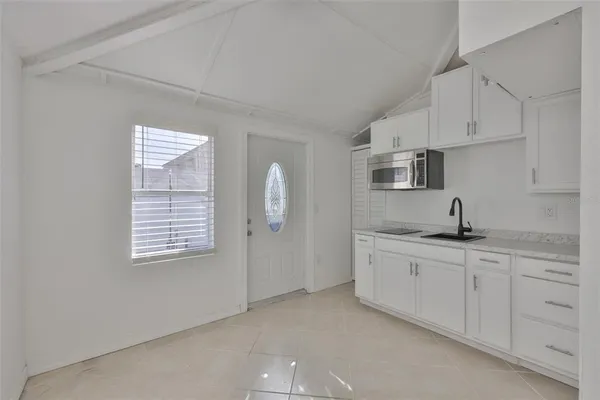 a kitchen with stainless steel appliances granite countertop white cabinets and sink