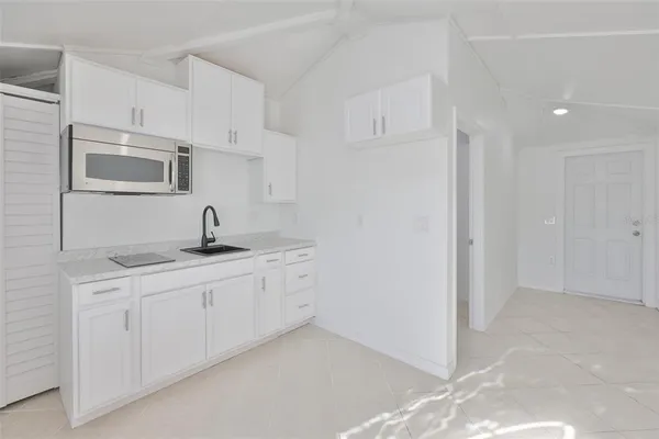 a kitchen with white cabinets and sink