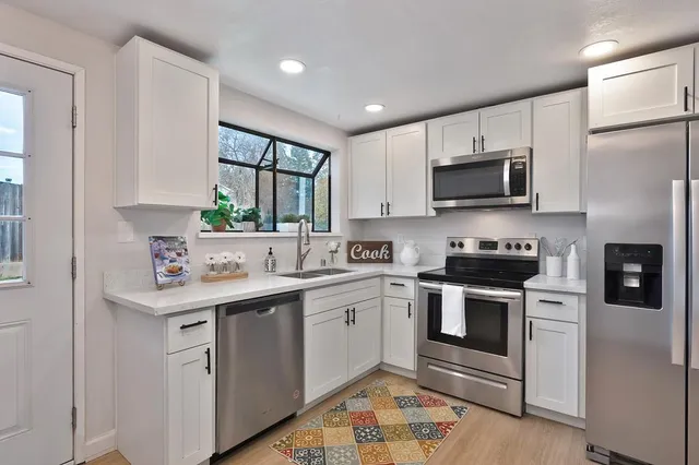 a kitchen with stainless steel appliances a stove sink microwave and refrigerator
