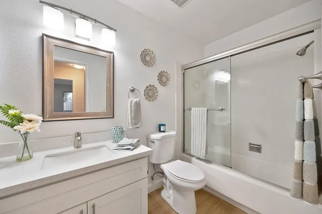 a bathroom with a sink a toilet and shower