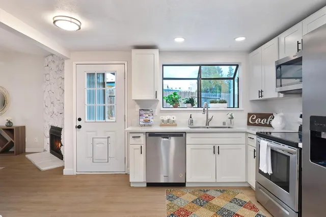 a kitchen with stainless steel appliances granite countertop a stove a sink and a refrigerator