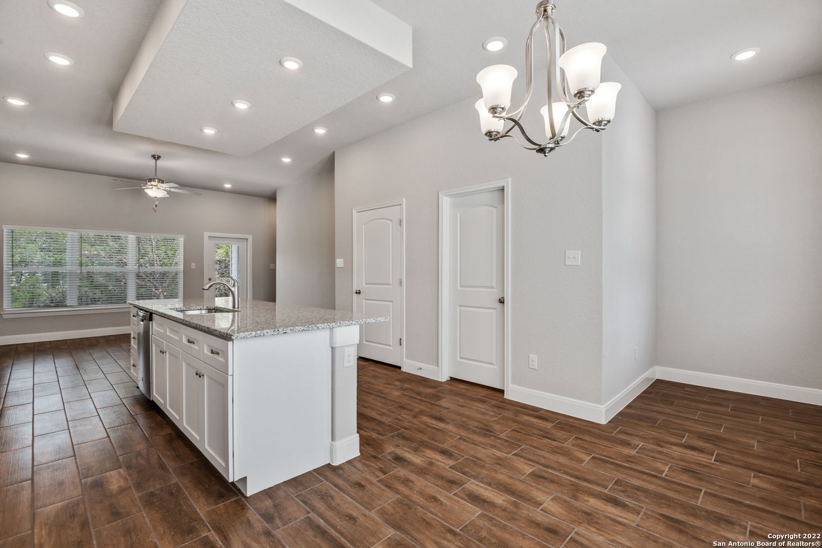 a kitchen with stainless steel appliances granite countertop white cabinets and wooden floor