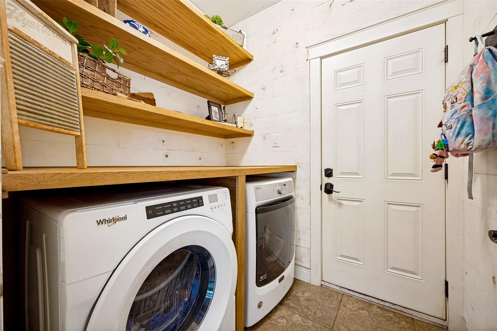 3105 Union Lake Road Denton, TX 76210 - Photo 22 of 27 Laundry area with built-in wood-finish shelving, shiplap-style wall paneling, and tile flooring