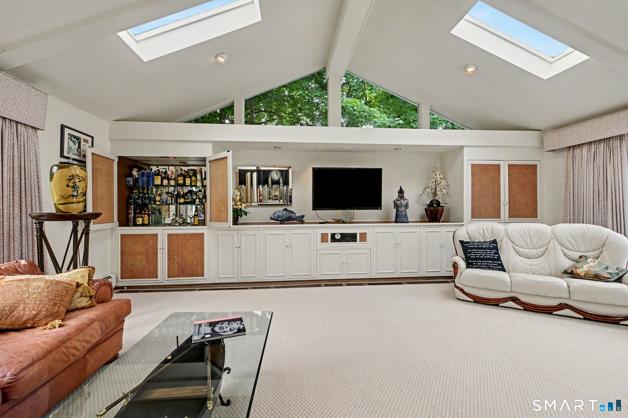 29 Old Logging Road Stamford, CT 06903 - Photo 14 of 38 Family room with fireplace, wet bar, vaulted ceilings and sliders out to the outdoor kitchen and pool