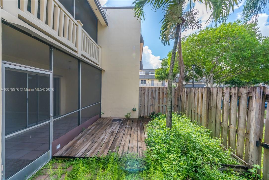 8375 Southwest 137th Avenue, Unit 8375 Miami, FL 33183 - Photo 13 of 30 a view of a backyard with potted plants and wooden fence