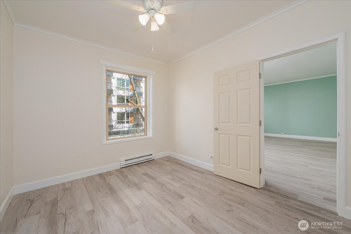 7 Harrison Street, Unit 20 Seattle, WA 98109 - Photo 12 of 27 an empty room with wooden floor chandelier fan and windows