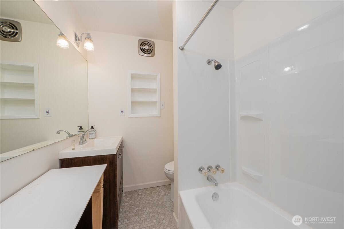 7 Harrison Street, Unit 20 Seattle, WA 98109 - Photo 15 of 27 a bathroom with a tub sink toilet and a mirror
