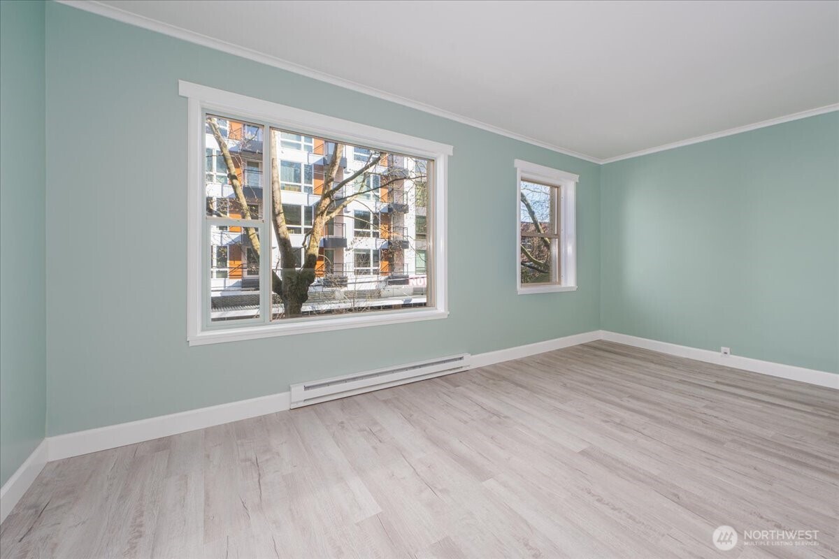 7 Harrison Street, Unit 20 Seattle, WA 98109 - Photo 6 of 27 a view of an empty room with wooden floor and a window