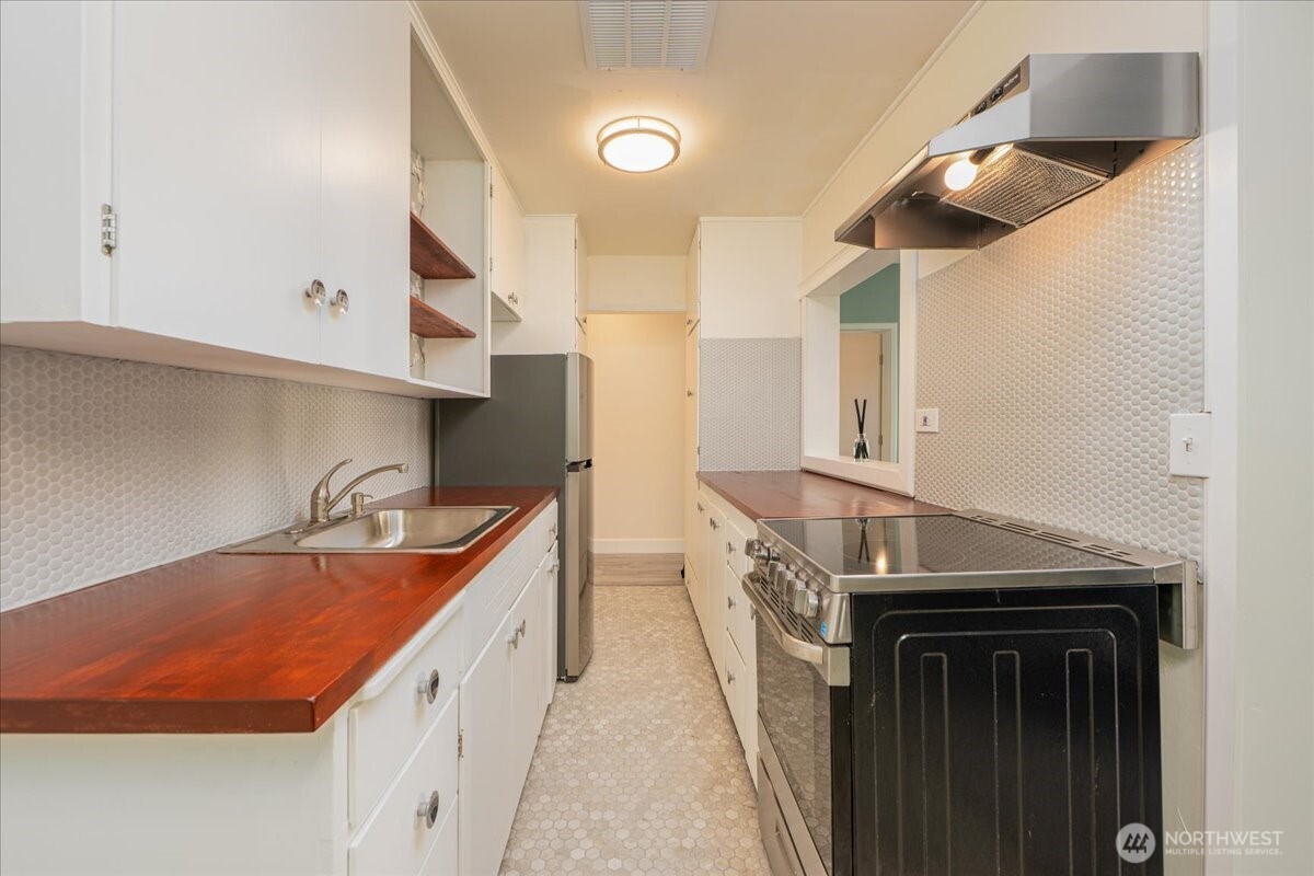 7 Harrison Street, Unit 20 Seattle, WA 98109 - Photo 9 of 27 a kitchen with stainless steel appliances granite countertop a sink and a stove