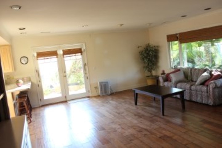 view of the enormous family room looking from the entry to the French doors to side patio and outdoor dining and breakfast area (if desired) off the kitchen (which sets to the left in the phots and is open to the family room.