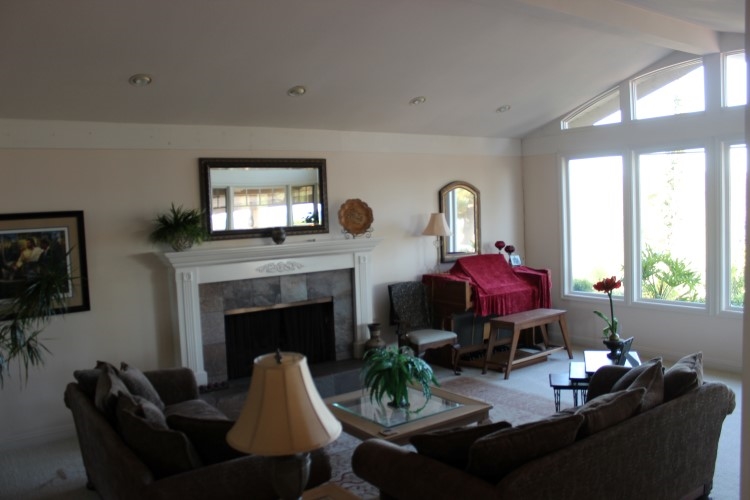 Another view of the living room from the dining room showing the attractive raised hearth fireplace  and vaulted ceilings!