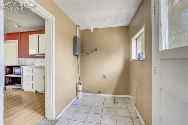 a view of an empty room with closet and a window