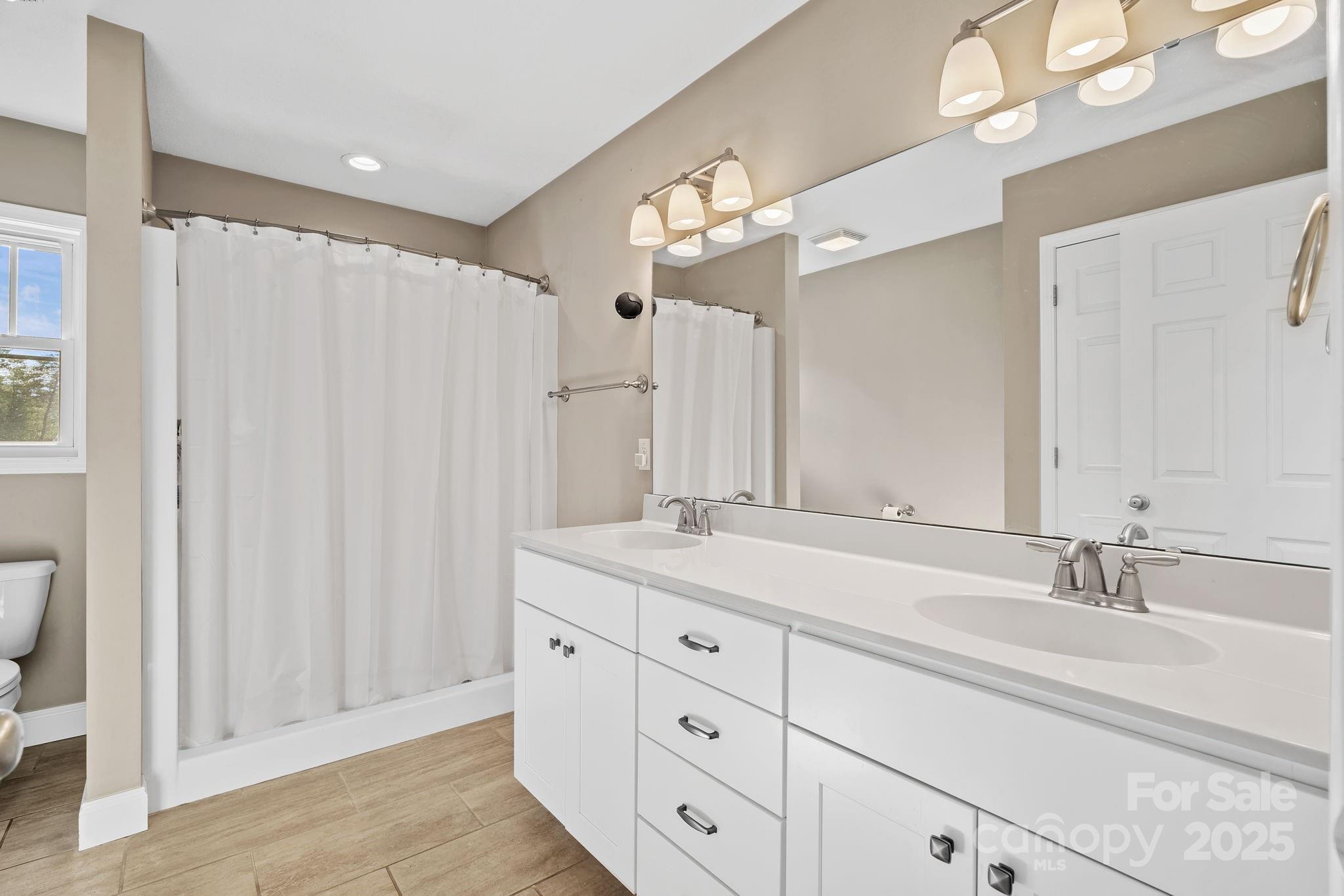 39 Curtis Miles Road Alexander, NC 28701 - Photo 20 of 37 a bathroom with a double vanity sink a mirror and a shower