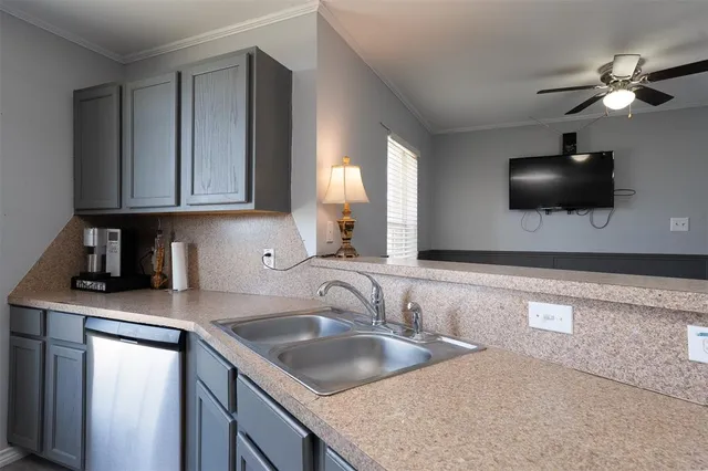 a kitchen with a sink a counter space and cabinets
