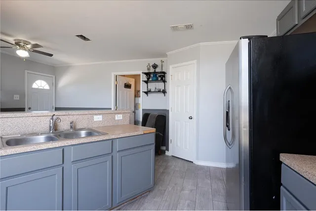 a bathroom with a granite countertop sink a refrigerator and a mirror
