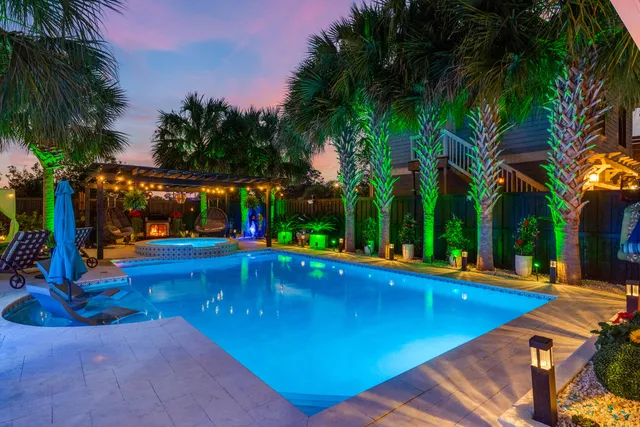 a view of swimming pool with lounge chair and palm trees