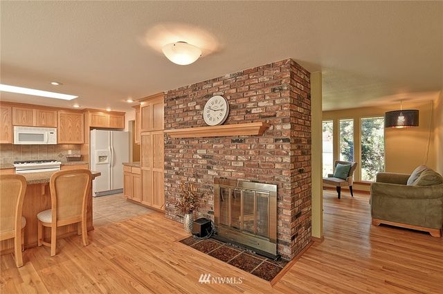 a living room with furniture a fireplace and wooden floor
