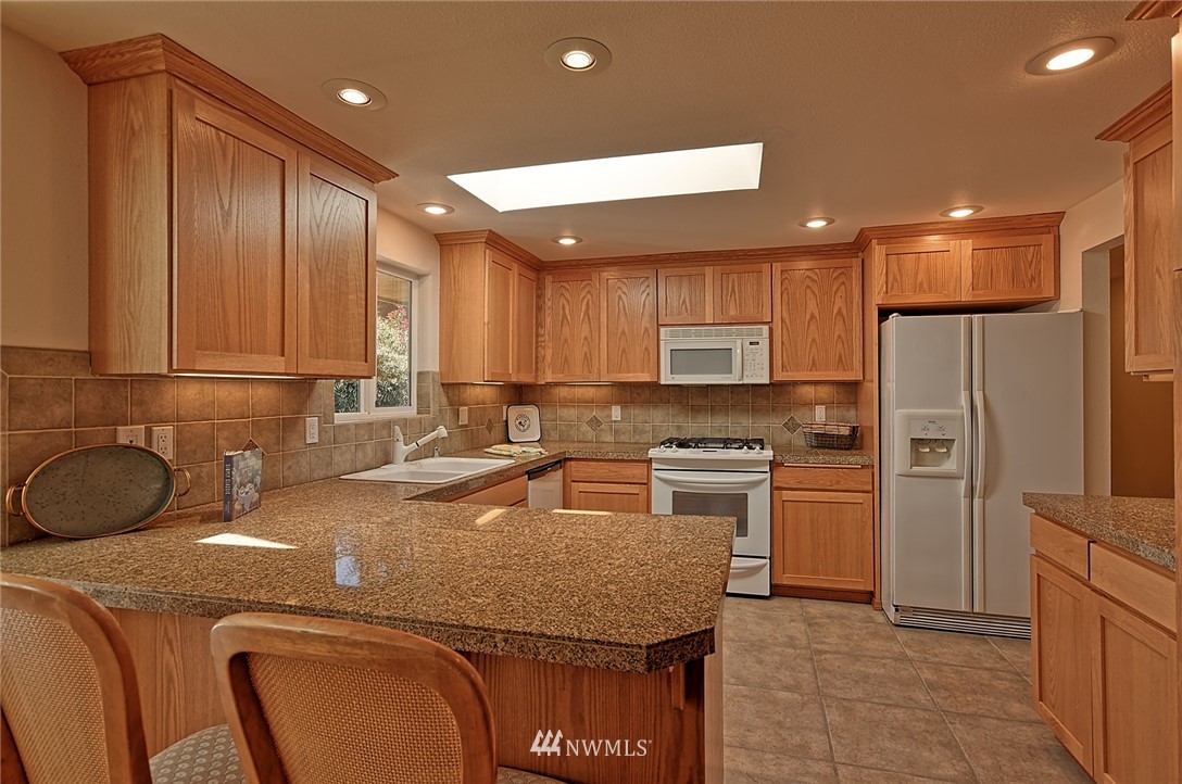 11619 31st Drive Southeast Everett, WA 98208 - Photo 9 of 30 a kitchen with a sink a refrigerator and cabinets