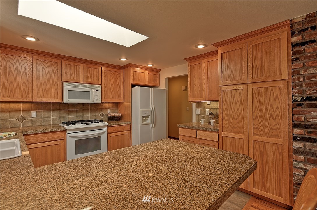 11619 31st Drive Southeast Everett, WA 98208 - Photo 10 of 30 a kitchen with granite countertop a refrigerator stove top oven and sink