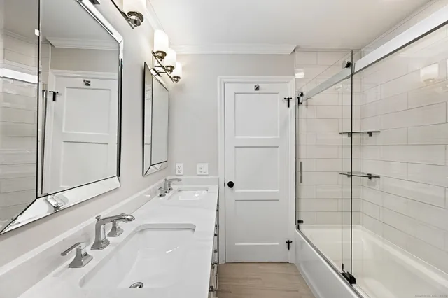 a bathroom with a sink and a mirror with bathtub