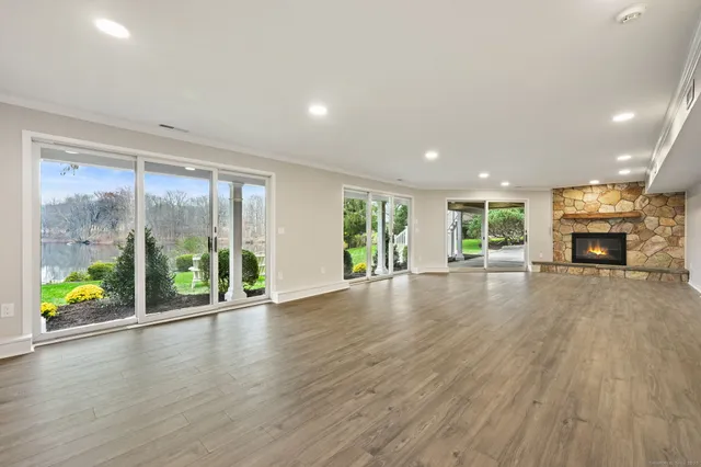 an empty room with wooden floor and fireplace
