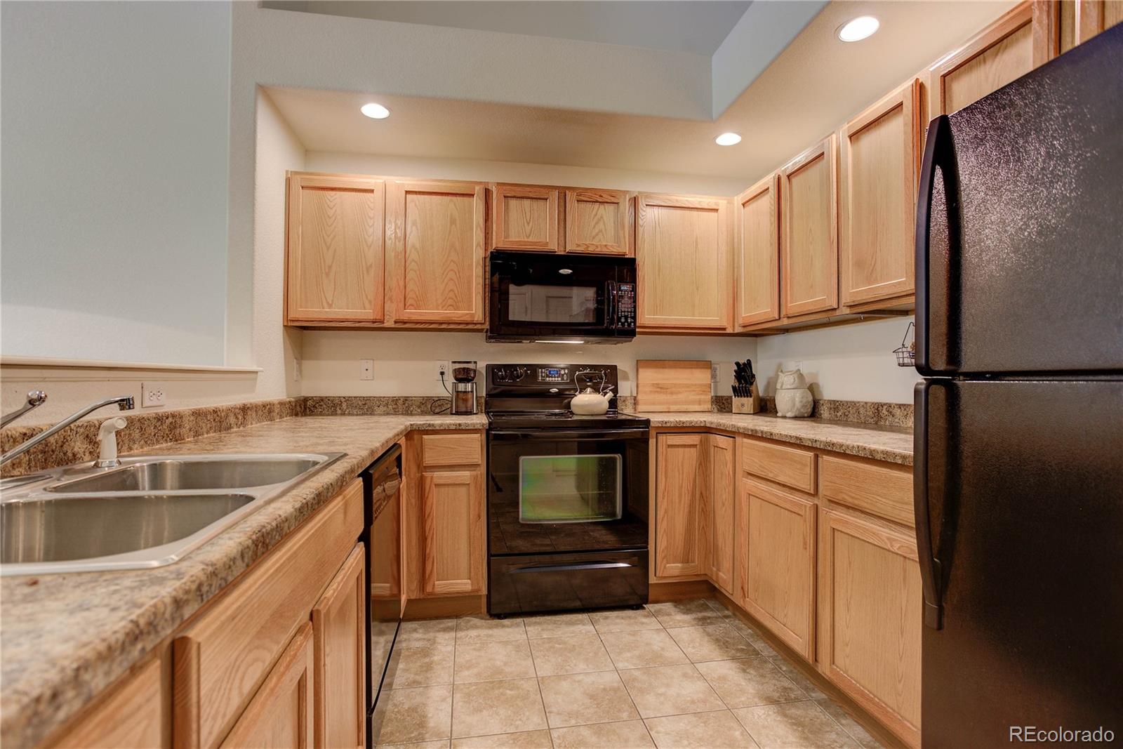 5800 Tower Road, Unit 2310 Denver, CO 80249 - Photo 10 of 29 a kitchen with a sink stove and refrigerator