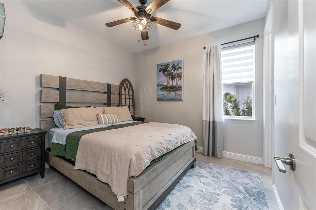 4185 Marina Way Deerfield Beach, FL 33064 - Photo 21 of 40 a bedroom with a bed and a chandelier