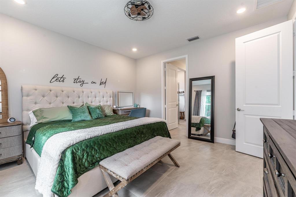 4185 Marina Way Deerfield Beach, FL 33064 - Photo 25 of 40 a bedroom with a large bed and a chandelier