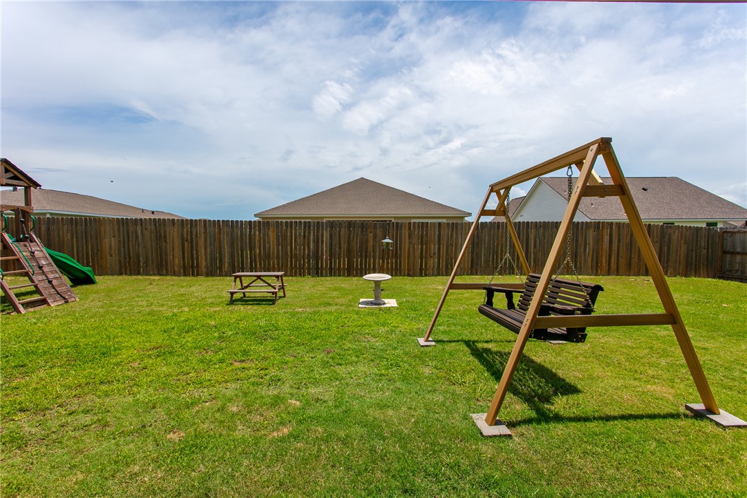 137 Windmill Road Somerville, TX 77879 - Photo 19 of 22 a view of a backyard with a slide and a child swing