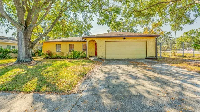 a view of a house with backyard and tree