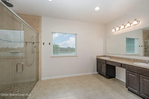 a spacious bathroom with a granite countertop sink and a mirror