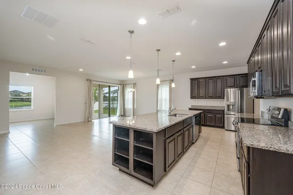 a kitchen with kitchen island granite countertop a large counter top stainless steel appliances and cabinets