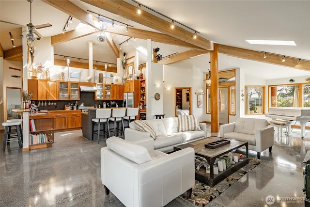 a living room with lots of furniture and a floor to ceiling window
