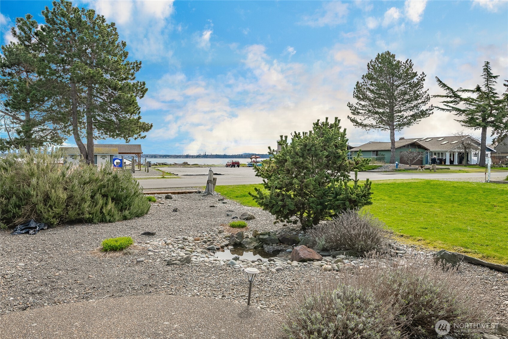 5382 Nootka Loop Birch Bay, WA 98230 - Photo 9 of 40 a view of a garden with a bench and trees in the background