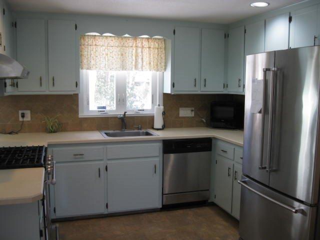 64 Ansel Howland Road Centerville, MA 02632 - Photo 14 of 31 a kitchen with a refrigerator sink and cabinets