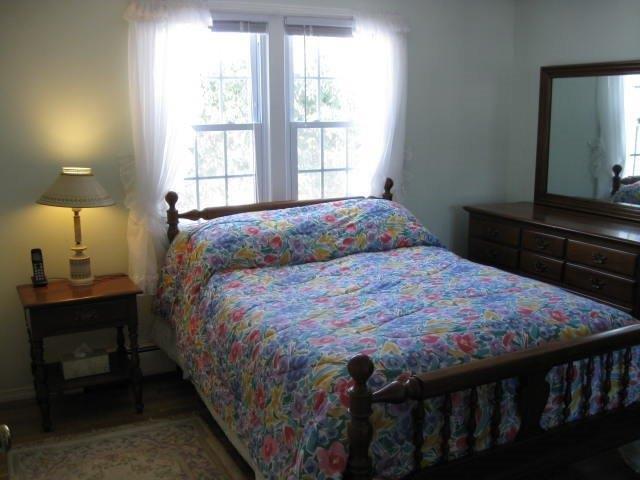 64 Ansel Howland Road Centerville, MA 02632 - Photo 27 of 31 a bedroom with a bed table and window