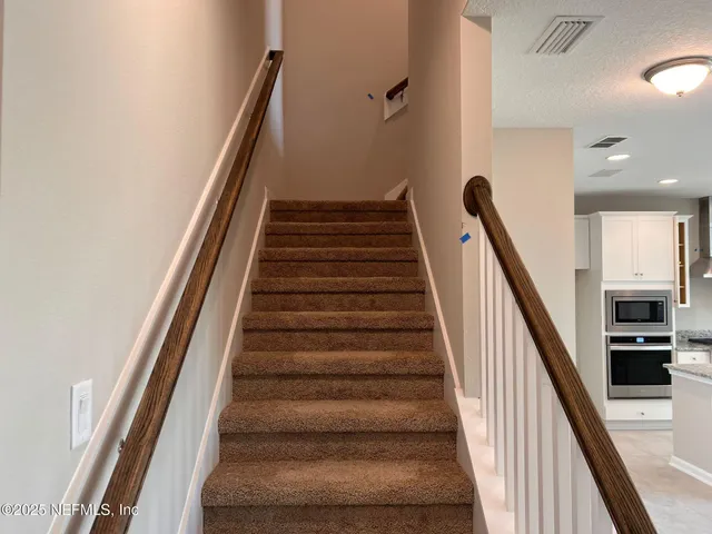 a patio with tables and chairs pool and a fire pit with wooden fence