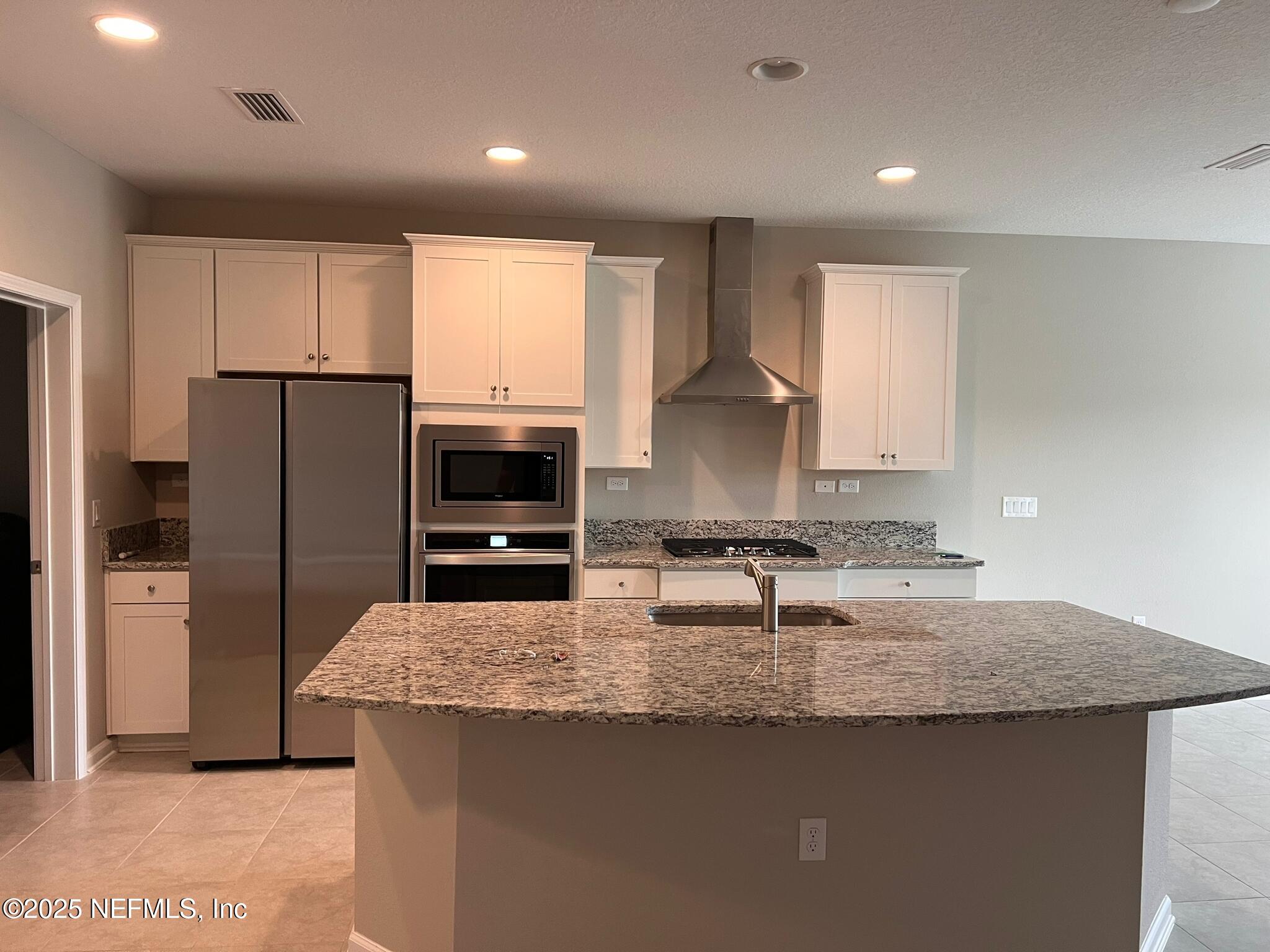 66 Goodhope Court St. Augustine, FL 32092 - Photo 3 of 31 a kitchen with granite countertop a refrigerator a sink a stove a microwave a counter top and cabinets