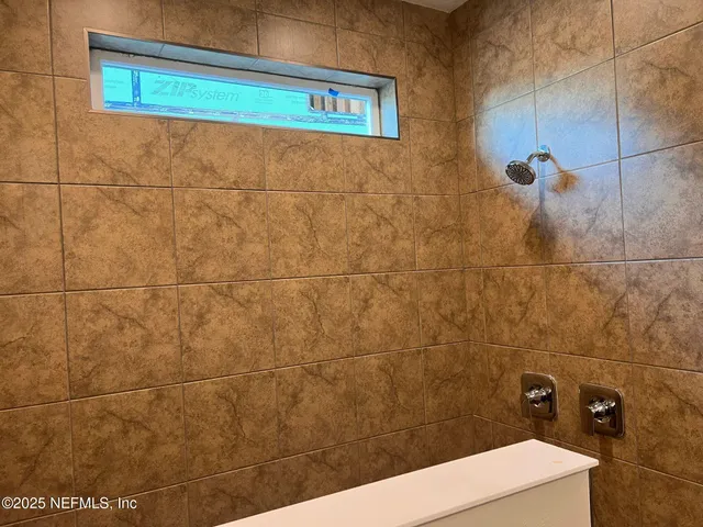 a bathroom with a granite countertop sink and shower