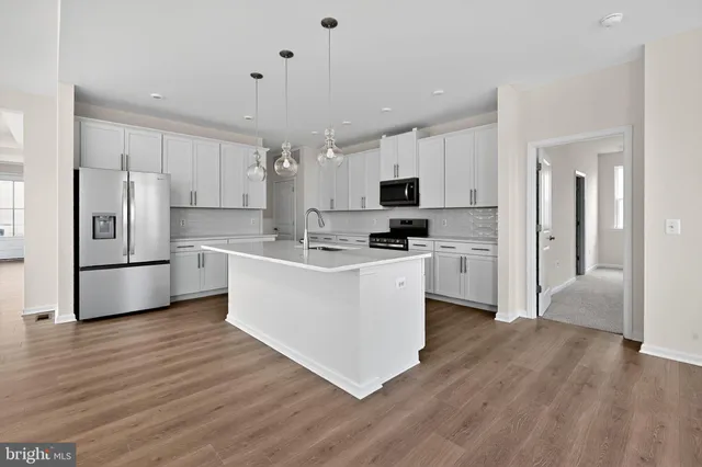 a kitchen with cabinets a refrigerator and a stove top oven