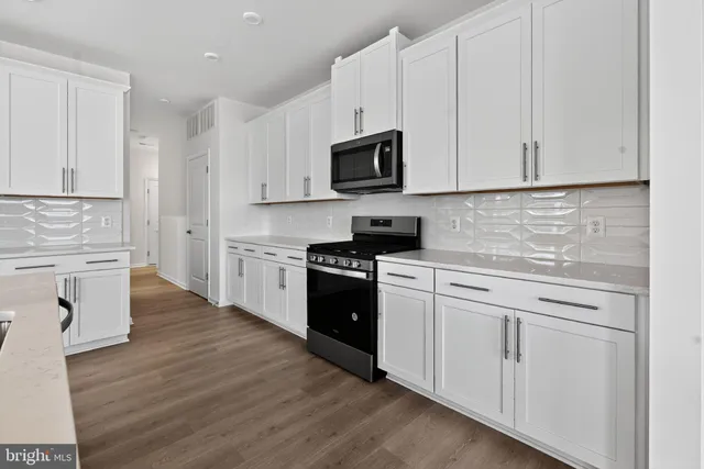 a kitchen with white cabinets appliances and sink
