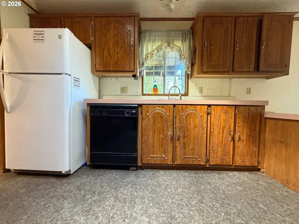 a kitchen with granite countertop wooden cabinets and a stove top oven