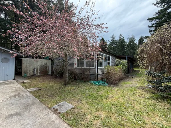 a view of backyard with seating space and wooden fence