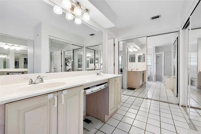 a spacious bathroom with a granite countertop sink mirror and shower