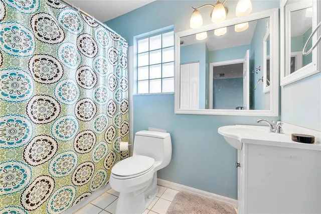 a bathroom with a toilet sink and mirror with painted walls